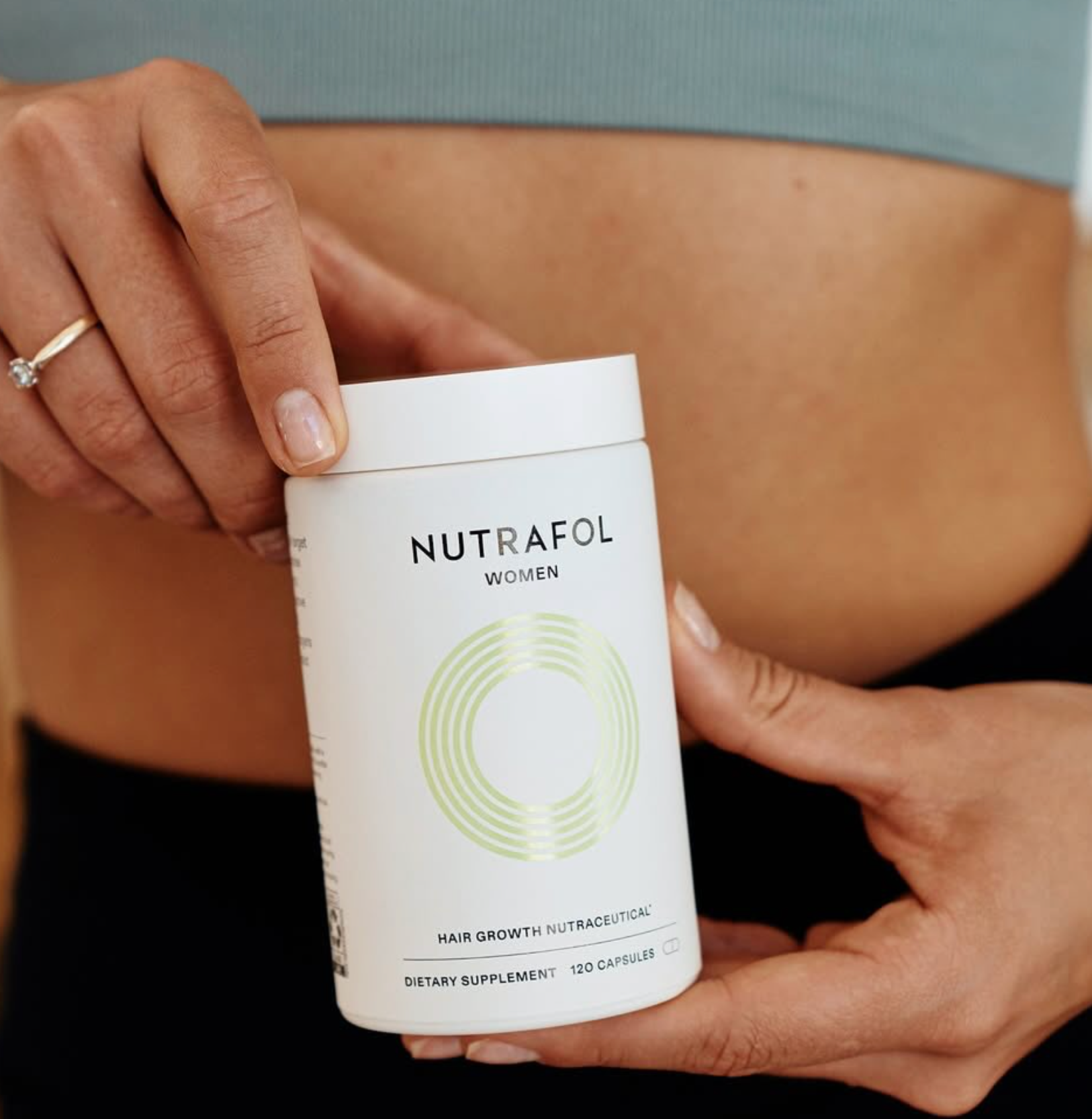 Woman Holding Bottle Labeled Nutrafol